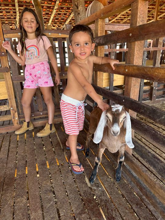 Criança da família com um cabrito na Fazenda Campinas